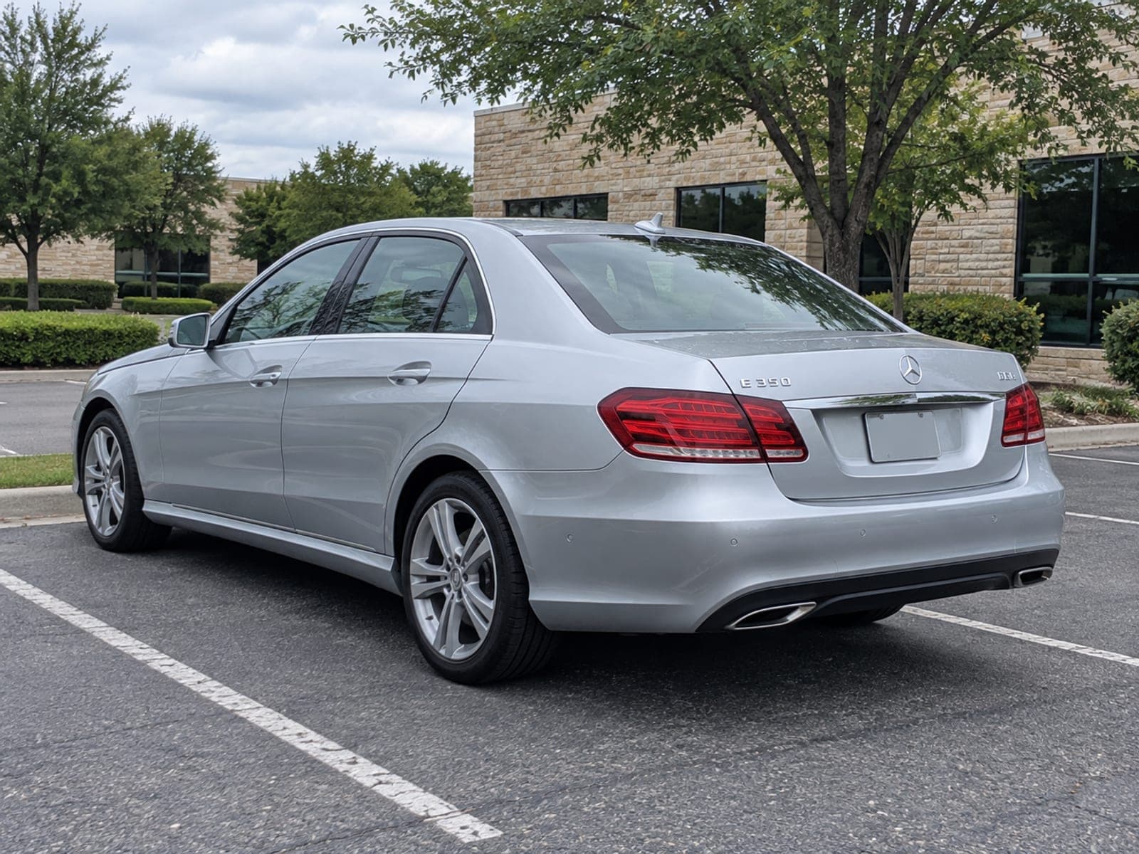 A clean dark sedan parked on a residential driveway after a detail