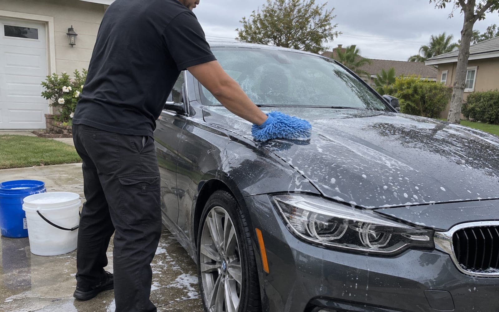 A foam-covered sedan on a home driveway