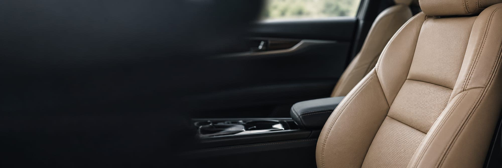 The tan leather front seat and console of a clean cabin